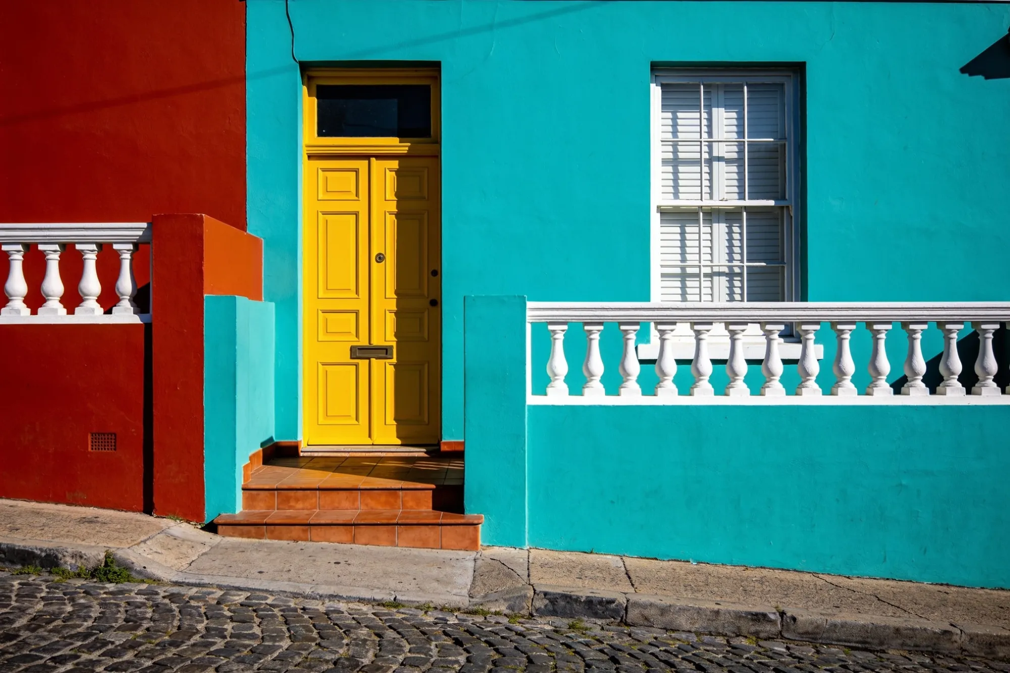 Foto — Un portal de color vivo y adoquines